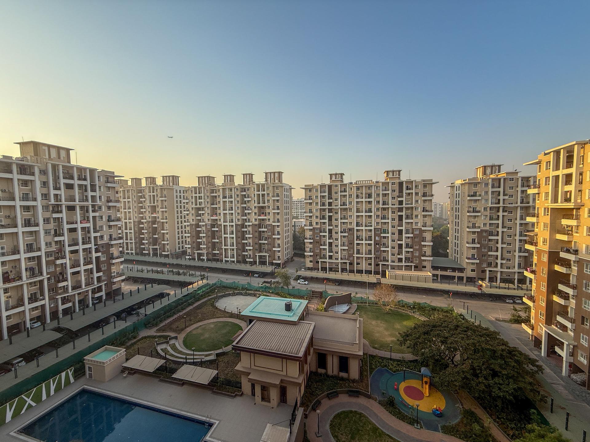 A view of a large apartment complex with a pool and a playground