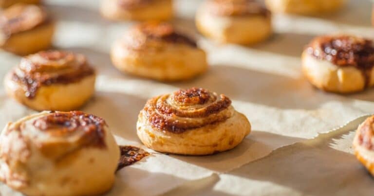 Freshly baked cinnamon buns on a tray at a rustic bakery