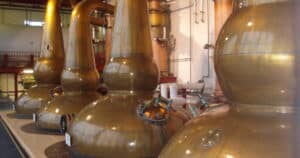 Gleaming copper pot stills inside a craft distillery